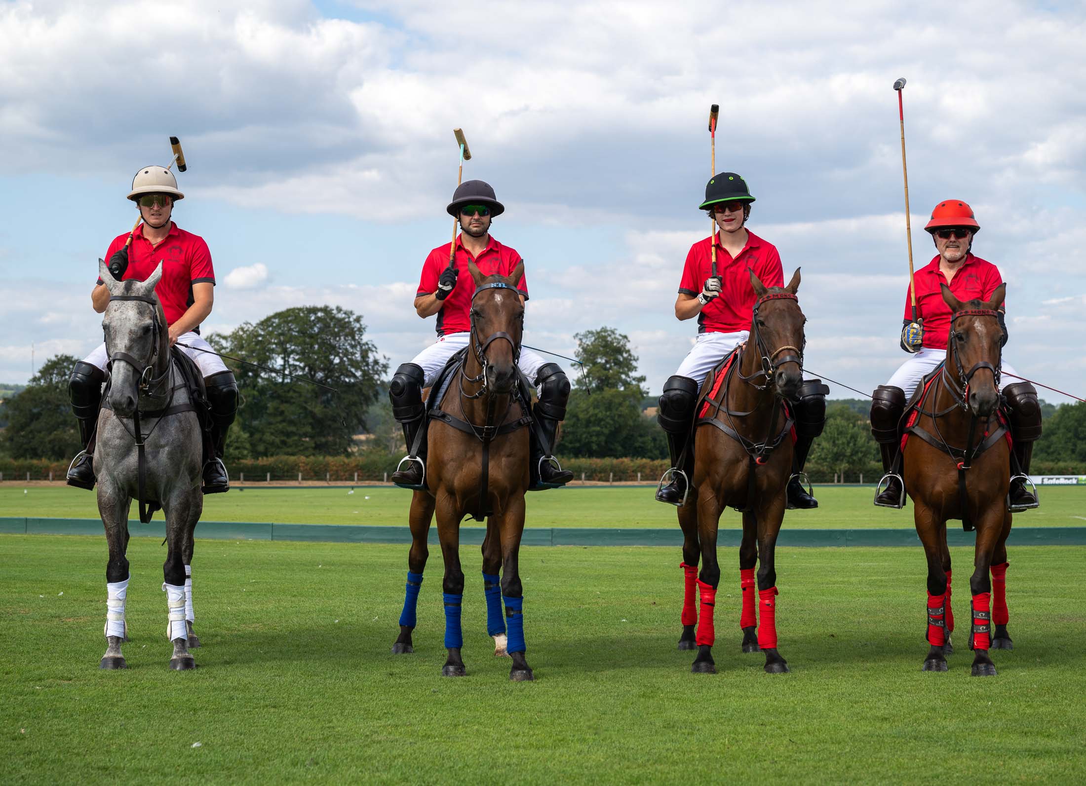 The Mono Polo team lined up on horseback, mallets raised, at Lodsworth